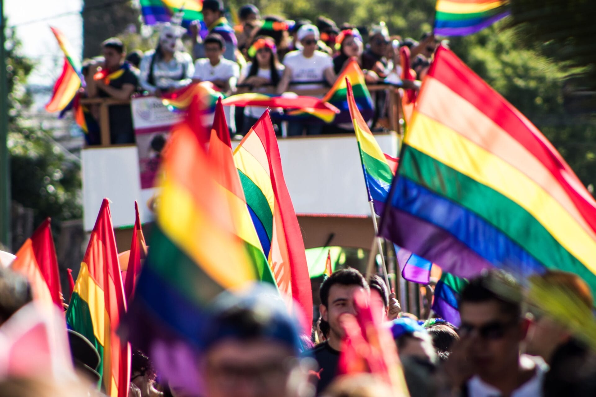 Colorful Pride parade in San Luis Potosí with rainbow flags and a lively crowd.